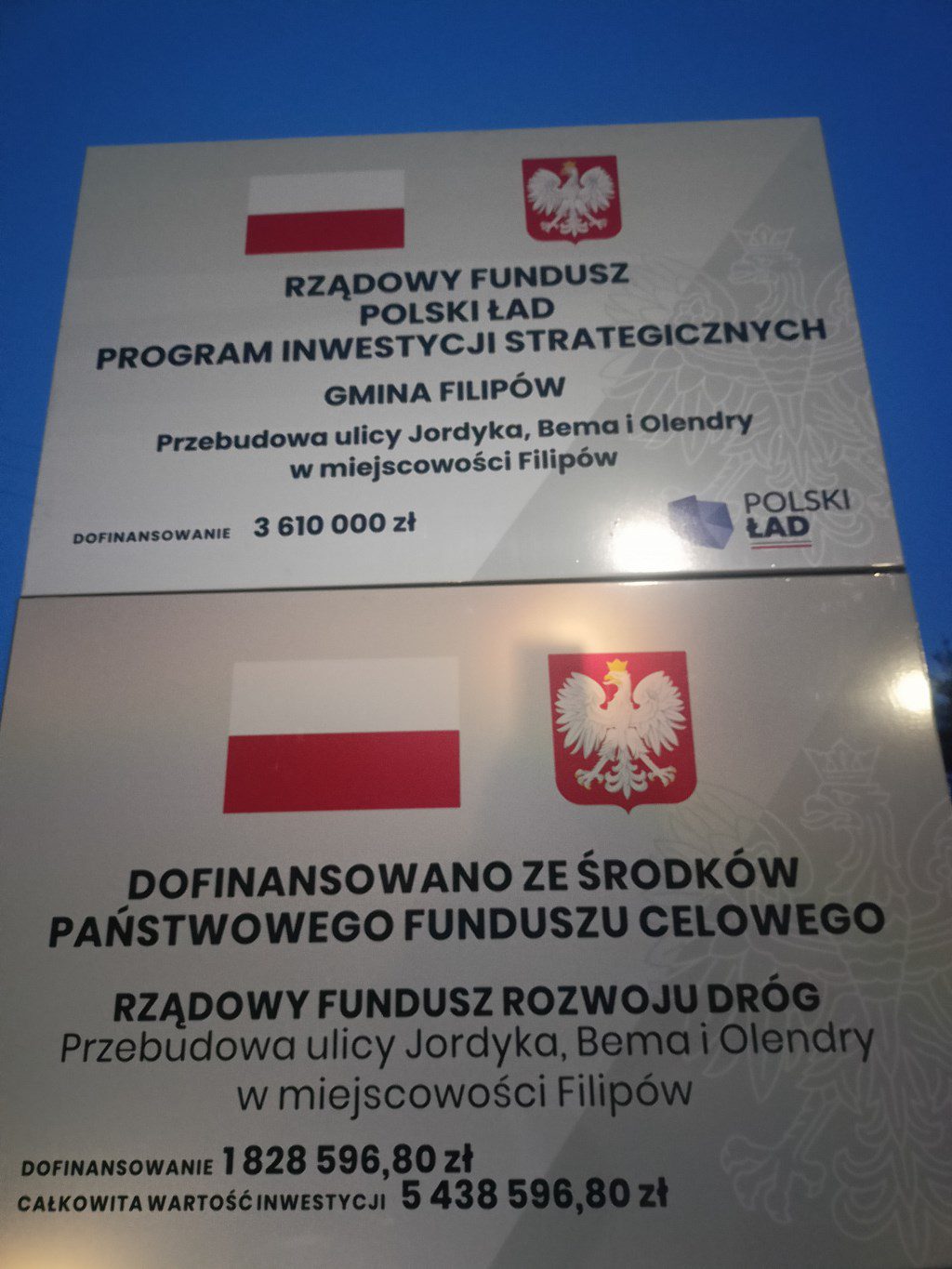 Tablice o dofinansowaniu przebudowy ulic w Filipowie: 3,61 mln zł z Polskiego Ładu i 1,83 mln zł z Funduszu Rozwoju Dróg